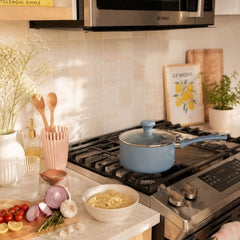 Blue ceramic non-stick sauce pan on stovetop with matching lid
