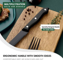 Black steak knife on a wooden cutting board with grip handle rivets