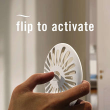Hand flipping the air freshener device tab to activate the unit