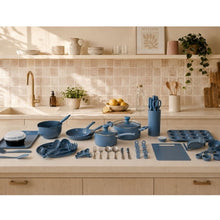 Blue ceramic non-stick cookware set on countertop with skillet, pots, and utensils