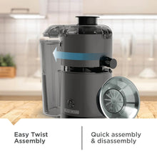 Fruit and vegetable juicer with clear cover, black base, and removable twist assembly