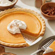 Sweet potato pie with a slice removed and whipped cream topping