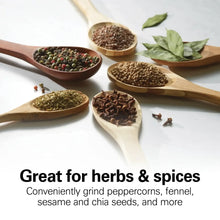 Wooden spoons filled with herbs, peppercorns, and seeds