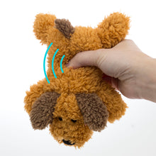 Plush orange floppy dog toy with brown paw accents held in a hand