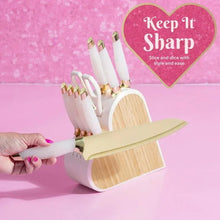 Heart-shaped knife block set with white iridescent handles; hand holds a white knife