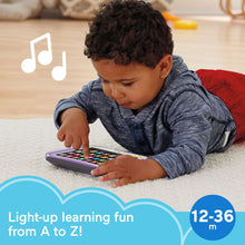 Toddler using light-up learning tablet with colorful letter buttons