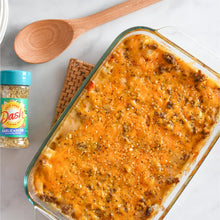 Dash salt-free garlic & herb seasoning blend bottle beside baked chicken dish