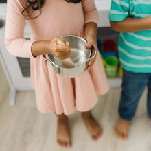 Kids pretend play stainless pot with lid and wooden utensil, held in hands