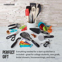 Countertop utensil set in white holder with assorted spatulas, ladles, and scoops