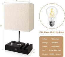 Fabric-shade bedside lamp with black charging base, chrome stand, USB and AC outlets