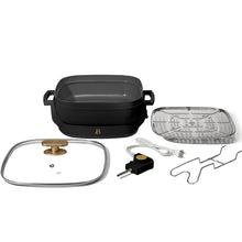 Black electric skillet set with glass lid, steam rack, and power cord