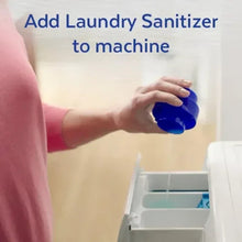 Hand pouring laundry sanitizer from blue-capped bottle into washing machine