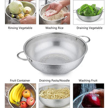 Stainless steel perforated colander with side handles for draining, shown in use