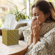Facial tissue box with tissues used while a person blows nose