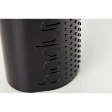 Electric coffee grinder body with textured grip and raised lettering, black finish