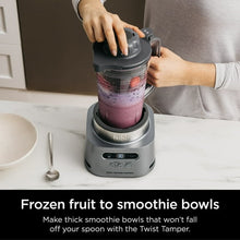 Gray blender base with clear to-go cup filled with purple smoothie and top cap