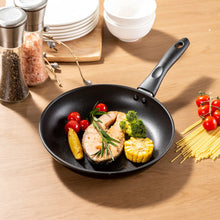 Black non-stick skillet holding chicken, vegetables, and corn