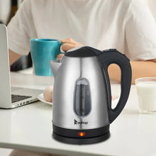 Stainless steel electric kettle on counter with black handle and spout, front water window.