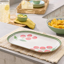 Oval serving tray with red tomato illustration and green leaf border