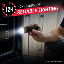 Handheld black tactical flashlight producing a focused beam