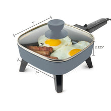 Gray 7-inch electric skillet with glass lid and measurement arrows for size