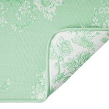 Green dish drying mat corner with white floral lining and stitched edging
