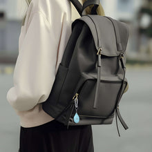 Blue wireless item locator attached to a black backpack strap