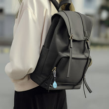 Blue onn item locator attached to black backpack with carabiner clip