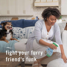 Pet odor-fighting fabric spray bottle held by person, green trigger