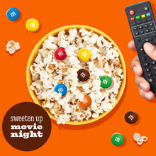 Bowl of popcorn with scattered M&M candies, viewed from above