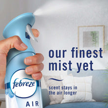 Hand holding Air Mist air freshener spray bottle with blue cap, trigger sprayer