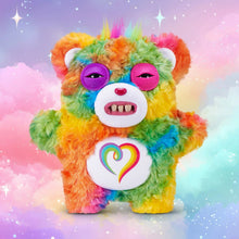 Rainbow fuzzy monster plush with purple eyes, open mouth, and heart chest badge