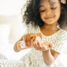 Child holding a pretend lip stick from a Love Your Look makeup tube