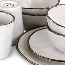 Close-up stoneware mugs with gold rim and matt white finish