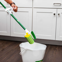 Sponge mop with built-in scrub brush using green handle and yellow foam pad.