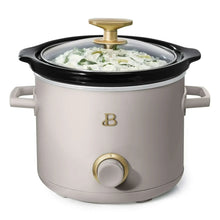 Manual slow cooker with glass lid, gold knob, light gray pot with food inside