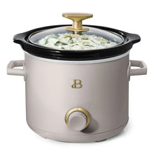 Manual slow cooker with taupe body, clear glass lid, gold knob, white dish