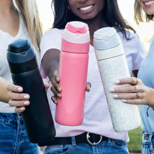 Coral pink 26 oz flip-top water bottle with straw spout, held upright