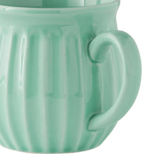 Close-up of green stoneware mug handle and ridged body