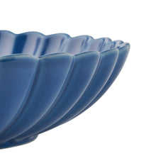 Blue stoneware serving bowl close-up, fluted ridges and scalloped rim