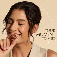 Woman tasting a green Lindor pistachio truffle, held near her mouth