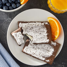 Frosted cookies and cream toaster pastries on a plate, with scattered sprinkles