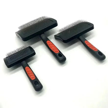Set of three black slicker grooming brushes with red grip buttons