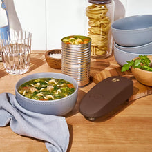 Chocolate-brown electric can opener beside a bowl of soup
