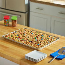 Half-size aluminum sheet pan on a kitchen table with a snack mix