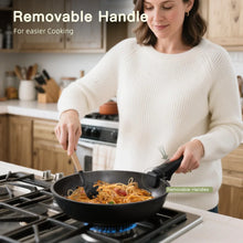 Black nonstick skillet with removable handle, stirring food on a gas burner