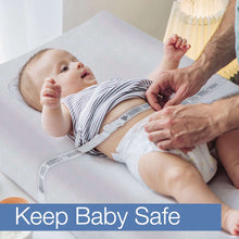 Changing pad with baby lying on top, white waterproof cover visible