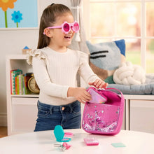 Toddler playing with pink sparkle purse set, toy keys and phone card on table