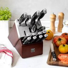 Knife block set with black-handled knives standing in red wooden block