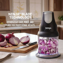 Gray food chopper with clear bowl holding chopped purple onions inside